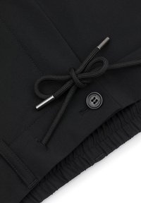 Czarne szorty z elastycznym paskiem z metalowym zapięciem, detalem w postaci guzika i gładką fakturą materiału. Dopasowany krój.