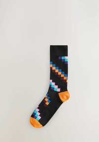 Sorte sokker med farverige pixelmønstre i pink, blå, lilla og orange accenter; orange tå og ribkant detalje. Blød, strikket tekstur.