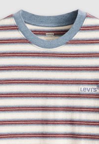 Rayonasta srajce s kratkimi rokavi v smetanasti, modri in rdeči barvi. Modra rebrasta ovratnica. Na sprednji strani je svetlo vijoličast logotip "Levi's". Mehka tekstura.