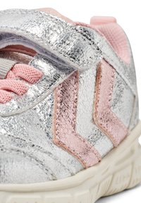 Silver sneakers med ett krinklat metalliskt avslut, rosa accenter, texturerad chevron-design och ett kardborreband för stängning.