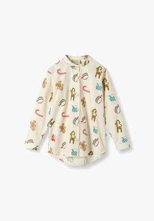 Maglietta a maniche lunghe per bambini in tessuto crema, con una stampa colorata di figurine di pan di zenzero, bastoncini di zucchero e regali. Design con bottoni.