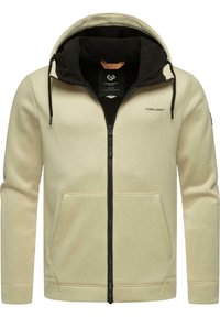 Felpa zip con cappuccio, di colore crema, dotata di cappuccio foderato in pile nero, due tasche frontali, texture a coste e zip e cordini neri a contrasto.