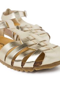 Sandali metallici dorati con cinturini incrociati, design open-toe, cinturino alla caviglia regolabile e suola in gomma texturizzata.