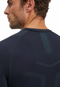 T-shirt de sport navy avec un motif texturé, doté de coutures ergonomiques et d'une coupe près du corps, fabriqué à partir d'un matériau extensible pour la performance.