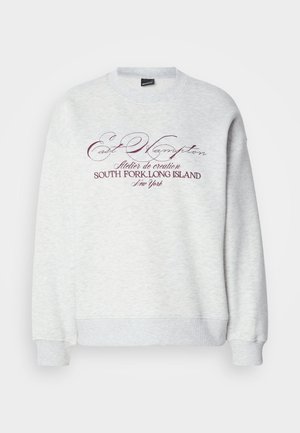 Sweatshirt cinzenta com mangas compridas, punhos e bainha canelados, com texto em borgonha a dizer "East Hampton" e detalhes adicionais abaixo.