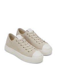 Sneaker beige con tomaia in suede, punta in gomma bianca e lacci. Presentano una texture liscia e un'etichetta con logo sulla linguetta.