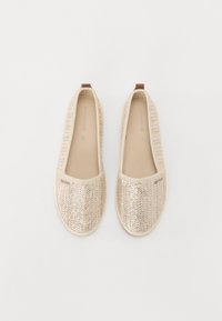 Slip-on sko laget av vevd beige materiale med metalliske detaljer. Rund tå og myk fôring; har en tan hæltab for enkel påføring.
