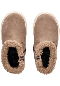 Botas de tobillo de ante marrón con un suave cuello de color beige, cremalleras laterales y una suela estructurada. En el interior cuentan con un forro suave y texturizado.