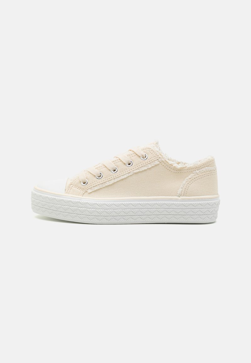 Beige canvas low-top sneakers with white rubber toe cap and textured sole. Includes five eyelets and a fluffy interior lining.