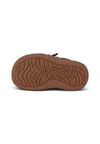 Suola in gomma marrone con un motivo ondulato testurizzato. Presenta il nome del marchio "WODEN" in evidenza, impresso in rilievo. Design resistente e flessibile.