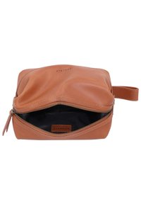Borsetta in pelle marrone con chiusura a zip, caratterizzata da una superficie liscia e foderata all'interno di nero. Include un piccolo manico e un dettaglio di branding.