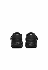 Baskets de sport noires avec une tige synthétique lisse, un talon arrondi, un col rembourré et une sangle ajustable, dotées d'une semelle en caoutchouc texturé.