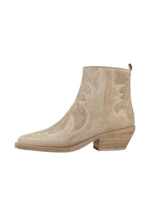 Botines de ante beige con detalles perforados y punta afilada. Tacón bajo apilado, con un sutil patrón a lo largo de los lados.