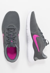 Grijze sportschoenen met ademende mesh bovenkant, roze accenten Swoosh-logo en witte rubberen buitenzool. Voorzien van ronde veters en een gevoerde kraag.