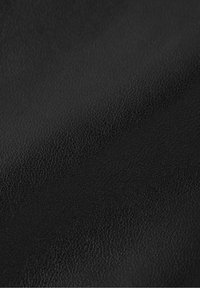 Svart texturerad läder med ett fint kornmönster, som har en slät yta som visar små variationer i nyans och djup.