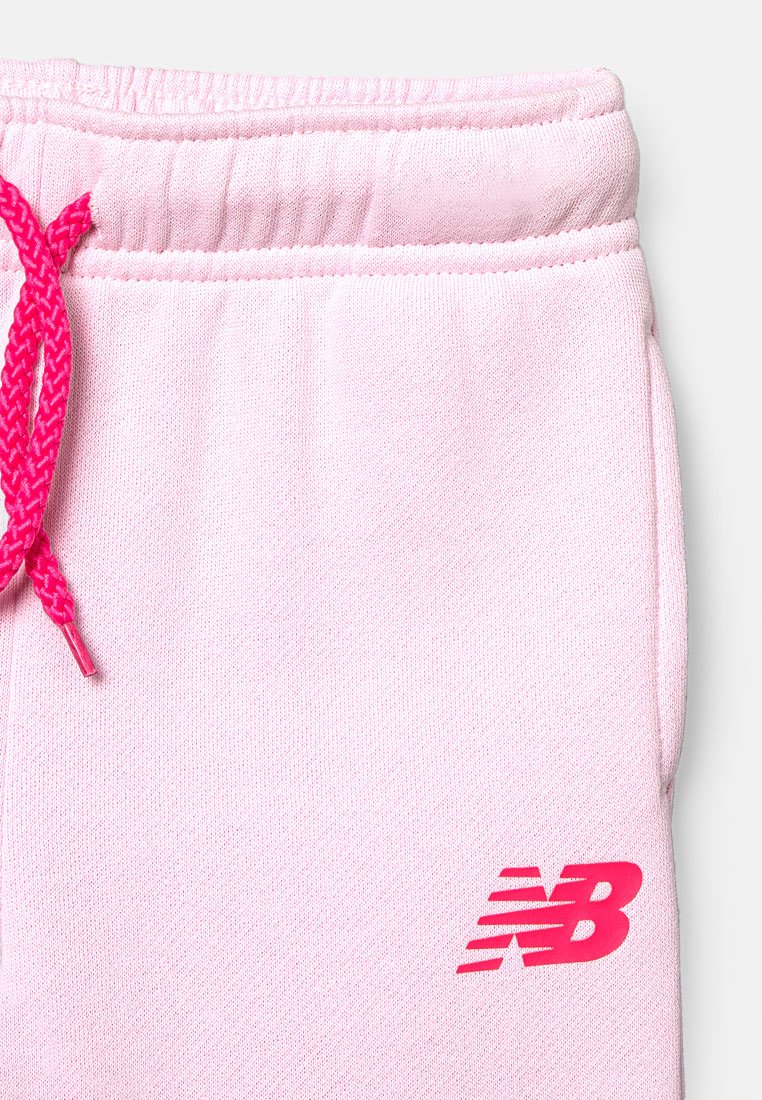Pantalon de survêtement rose avec une finition texturée, doté d'un cordon de serrage rose vif et d'un logo New Balance de couleur rose foncé contrastante sur la cuisse.