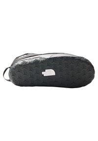 Czarna sneaker z teksturowaną gumową podeszwą, z wyrazistym logo na boku, gładkim materiałem górnym i zaokrąglonym czubkiem.