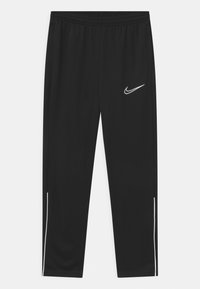 Pantalones deportivos negros con una pretina elástica, que presentan un logo de Nike blanco y franjas laterales blancas a lo largo de las piernas. Textura de tela suave.