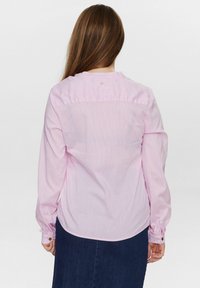 Camicia a maniche lunghe a righe rosa realizzata in un tessuto leggero, con orlo arrotondato, dettagli con bottoni sui polsini e un bottone al colletto.
