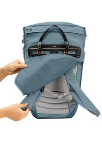 Blauer Stoffrucksack mit einer Frontöffnung, grauem gepolstertem Innenraum, verstellbaren Trägern und orangefarbenen Akzenten an den Beschlägen.