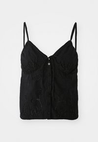 Svart singlet med tynne stropper, med en knytefrontlås, knappdetaljer og intrikate broderte mønstre på stoffet.