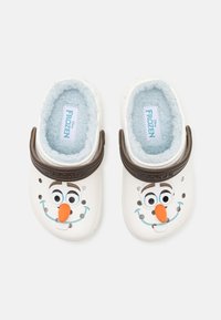 Zoccoli a tema Disney Frozen, in plastica bianca con una morbida fodera blu. Presentano un design con il viso di Olaf e una fascia regolabile marrone.