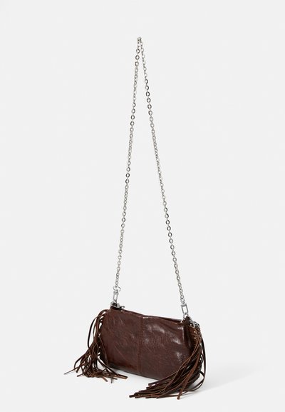 Hnedá kožená crossbody kabelka so strieborným reťazovým popruhom, zdobená bočnými strapcami a hladkým povrchom. Uzatváranie na vrchu pre bezpečný prístup.
