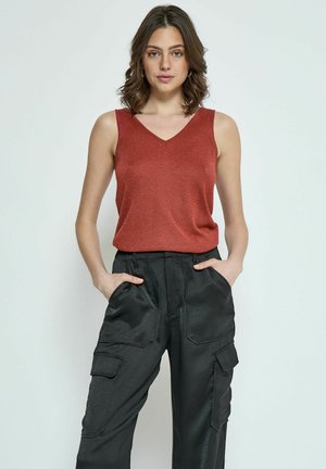 Haut sans manches de couleur rouille avec un décolleté en V, associé à un pantalon cargo noir doté de poches latérales et d'une texture lisse.
