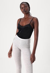 Black lace-trimmed camisole with thin straps paired with light gray marled leggings, featuring a soft texture and form-fitting design.