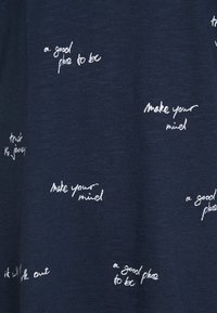 Tela azul oscuro con frases escritas a mano en blanco que se repiten, incluyendo "un buen lugar para estar", "haz tu mente", "confía en el viaje" y "todo saldrá bien".