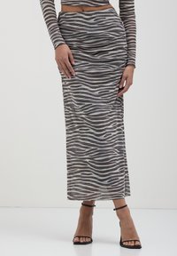 Gonna maxi in tessuto grigio trasparente con motivo a strisce zebrate. Presenta uno spacco laterale e una texture arricciata in vita per un design attillato.