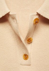 Beige gestreiftes Poloshirt mit Kragen und drei bernsteinfarbenen Knöpfen. Der Stoff hat eine weiche Textur, die das lässige Design unterstreicht.