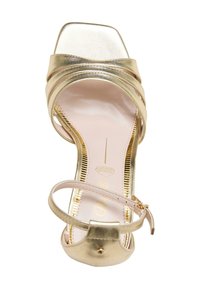 Sandal con tacco alto in metallo dorato, con punta quadrata, cinturini incrociati e una delicata cinghia alla caviglia. Presenta una soletta rosa imbottita.
