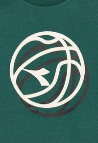 Maglietta verde con un motivo grafico circolare in bianco e nero, che rappresenta linee e forme intrecciate, con una texture liscia.