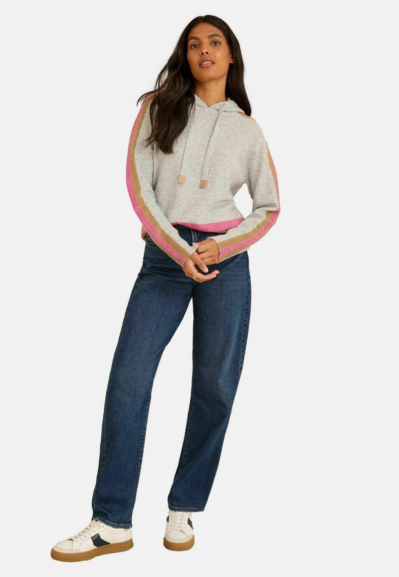 Szara krótka bluza z kapturem z różowo-złotymi paskami na rękawach, zestawiona z ciemnoniebieskimi dżinsami i białymi trampkami. Posiada kaptur i sznurek.