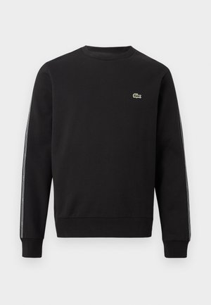 Μαύρο φούτερ με στρογγυλή λαιμόκοψη, με μικρό πράσινο λογότυπο κροκόδειλου στο στήθος και λωρίδα με επώνυμη ταινία κατά μήκος και των δύο μανικιών.