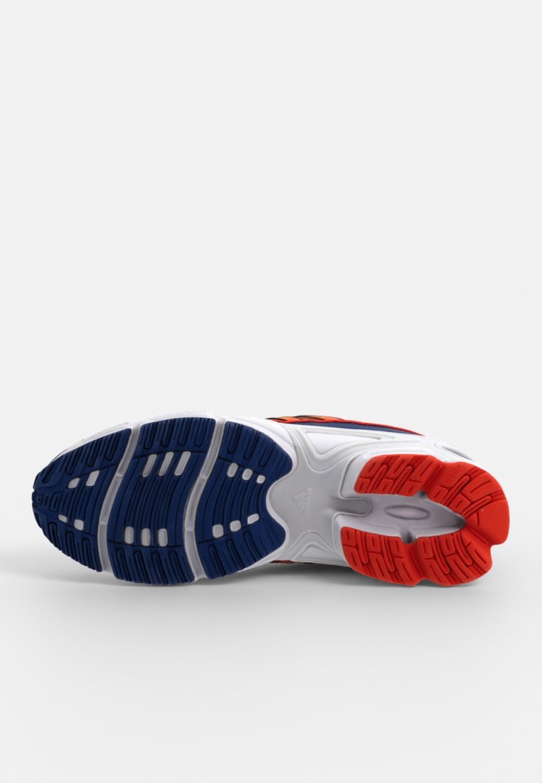 Suola di scarpa atletica multicolore con gomma blu, rossa e bianca. Trazione testurizzata per grip e stabilità con dettagli del logo.