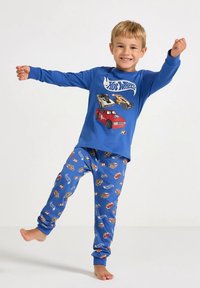 Blauw pyjamashirt met lange mouwen en een "Hot Wheels"-afbeelding; blauwe broek met kleurrijke autoprints; katoenmateriaal; zachte textuur.