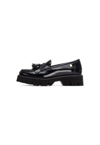 Mocasines de charol negro con una suela de goma negra gruesa, que cuentan con un borlón decorativo y un acento metálico en el lateral.