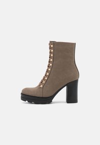 Taupe ankle boot z gładką fakturą, z koronkowym wykończeniem w złotym odcieniu, okrągłym noskiem i wysokim, blokowym obcasem.