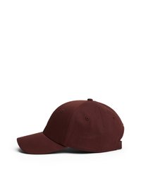 Cappello da baseball bordeaux con visiera curva, design a sei pannelli e fori di ventilazione cuciti. Realizzato in tessuto texturizzato con cinturino regolabile.