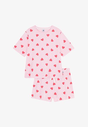 Ensemble de pyjama rose comprenant un haut à manches courtes et un short assorti. Les deux vêtements présentent des motifs de cœurs rouges éparpillés. Matière en coton doux.