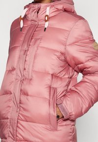 Różowa pikowana kurtka z kapturem, z przednim suwakiem, zatrzaskami i bocznymi kieszeniami. Teksturowana powierzchnia z połyskującym wykończeniem oraz ściągaczami na mankietach.