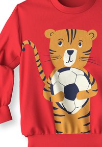 Sweatshirt en polaire rouge avec un tigre de bande dessinée tenant un ballon de football. Les poignets et l'ourlet sont côtelés, avec une texture lisse et des couleurs vives.