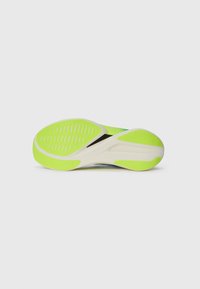 Shoe sole in white with vibrant lime green accents, featuring a textured pattern for grip and a sleek, curved design.