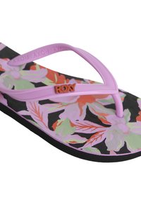 Lila flip-flop med blommönster i rosa, grönt och rött mot en svart bakgrund, med en strukturerad sula och en märkesstrap.