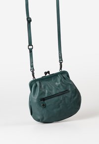 Türkise Leder-Umhängetasche mit runder Form, gefaltetem Design und Reißverschlusstasche an der Seite; verstellbarer Riemen mit Schnallen-Details.