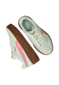 Witte sneakers met een zachte textuur, roze accenten en een bruine rubberen zool. Voorzien van veters, een logo en een gebogen ontwerp aan de zijkant.