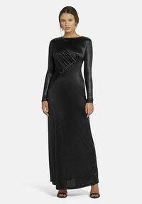 Schwarzes langärmliges Kleid aus glattem, glänzendem Stoff. Mit einem diagonalen gerafften Design über der Vorderseite. Bodenlang mit einer figurbetonten Silhouette.