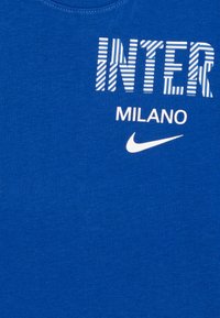 T-shirt en coton bleu avec le texte "INTER" en rayures blanches et "MILANO" en dessous, accompagné d'un petit logo Nike blanc. Encolure ronde.